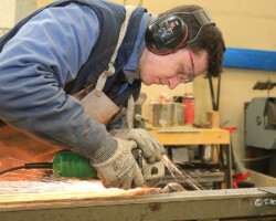 Photographie industrie - atelier de métallerie - Photo. sensible... au naturel Plan serré d'un jeune métallier dans une entreprise de serrurerie tuyauterie à GENNES-VAL-DE-LOIRE (49)